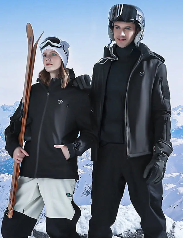 Model wearing a black heated jacket while skiing, showcasing warmth and mobility during winter sports.