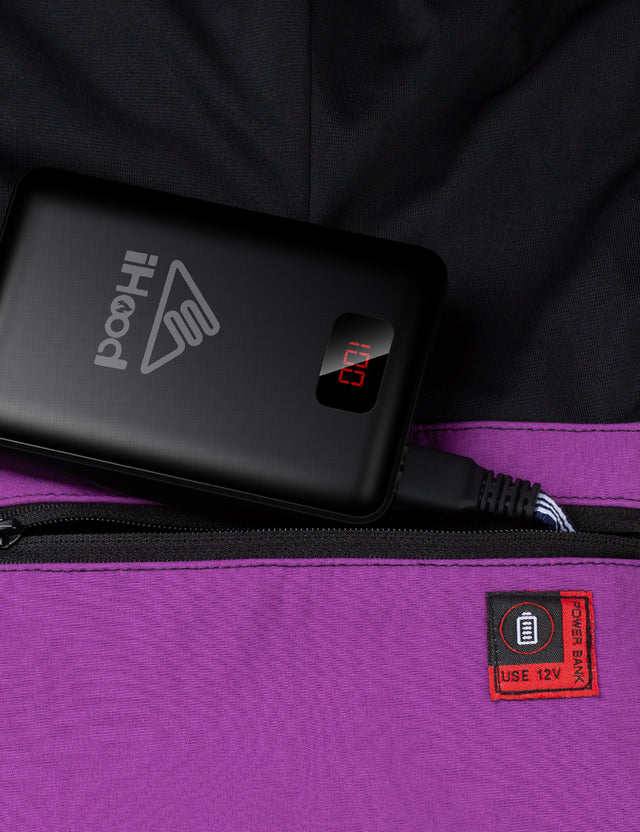 Close-up of the functional pockets on the purple women'sheated jacket, designed for battery storage